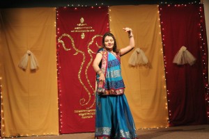 A lady performing a dance in a three piece dress known as a Lengha